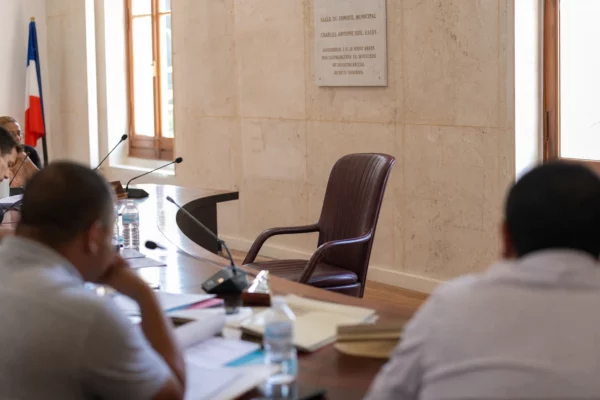 Salle municipale à Cucuta avec chaise vide, micros et dossiers flous, dans un contexte de tension sécuritaire en Colombie.