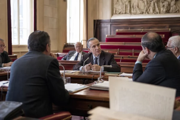 Débat parlementaire français en 1962, avec élus anonymes, micros et dossiers autour d’une table institutionnelle