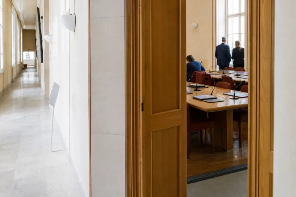 Hall clair d’une institution publique française avec salle d’audition, dossiers et micros pour un débat économique