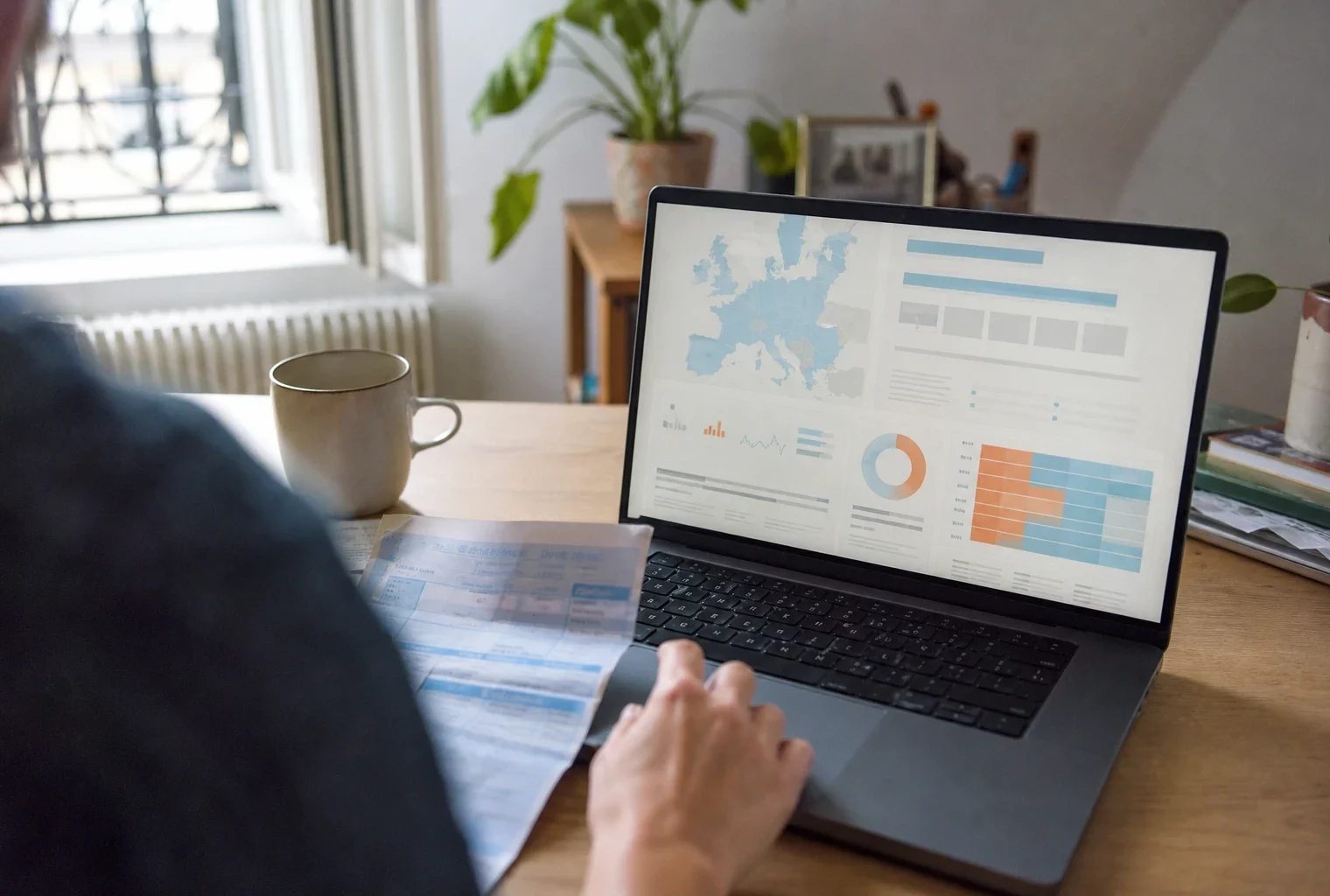Salarié français consultant une interface économique européenne abstraite sur ordinateur, dans un espace de travail quotidien