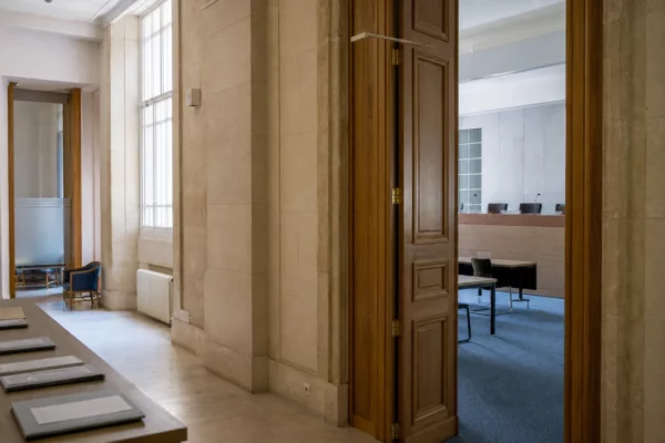 Hall clair d’un régulateur financier français avec salle d’audition et dossiers liés à la dette publique