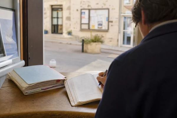 Élu local anonyme consultant un dossier dans une mairie française, avec une rue en arrière-plan flou