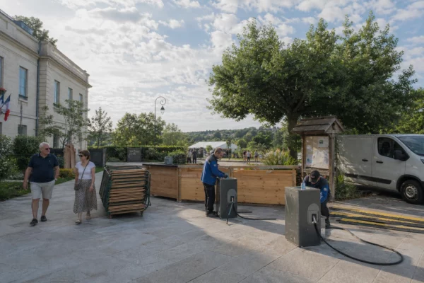 Préparation d’un festival musical à Saint-Cloud avec des travailleurs et des habitants dans un espace public lumineux