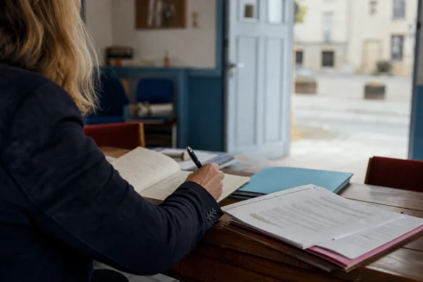 Élu local anonyme annotant un dossier dans une mairie française avant les élections sénatoriales