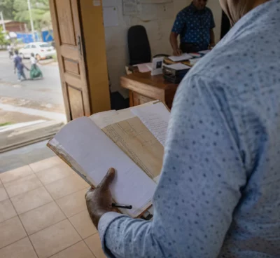 Élu local anonyme consultant un dossier à la mairie de Mayotte, dans une lumière naturelle et un cadre civique réel