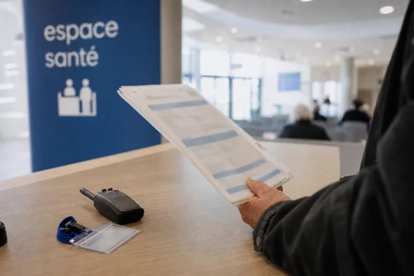 Main tenant un dossier de remboursement de soins dans un hall clair de service public français