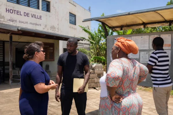 Habitants anonymes échangeant devant une mairie de Mayotte dans un contexte de reconstruction et de débat migratoire