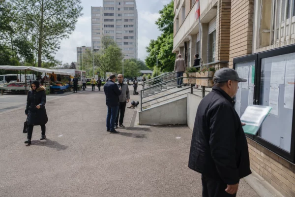 Rue de La Courneuve avec habitants anonymes, marché local et immeubles de logement social en lumière naturelle