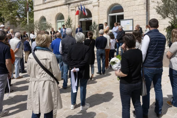Marche blanche à Bollène devant la mairie, avec des habitants anonymes rendant hommage à une victime de féminicide