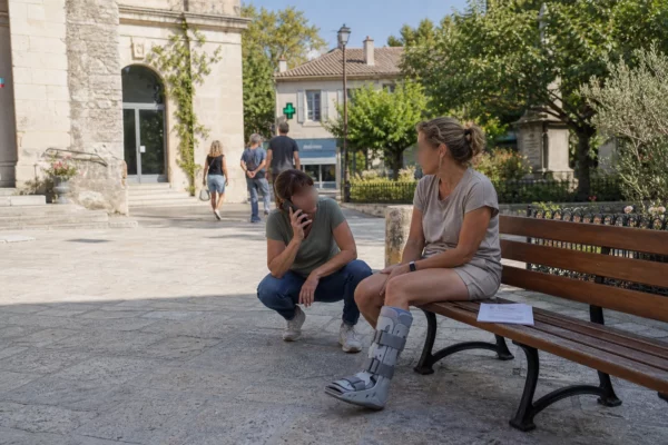 Femme anonymisée avec la jambe immobilisée sur une place de la Drôme après une morsure de vipère