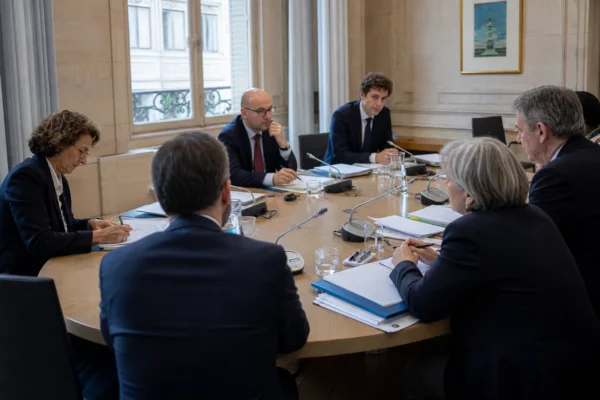 Réunion diplomatique franco-saoudienne autour d’une table dans une salle institutionnelle française