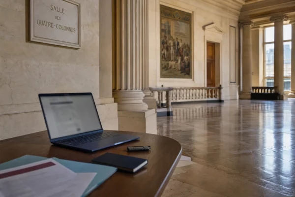 Salle parlementaire française avec ordinateur sécurisé et dossier flou, évoquant le piratage des données fiscales
