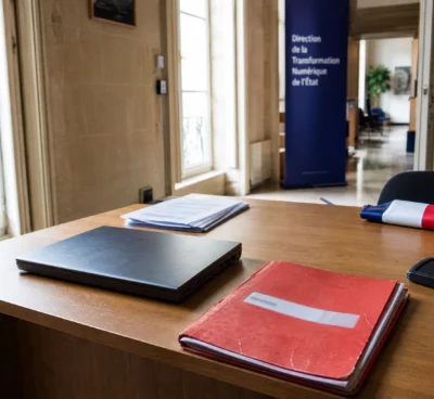 Bureau administratif français avec ordinateur fermé et dossier rouge, évoquant la sécurité des données fiscales de la DGFiP