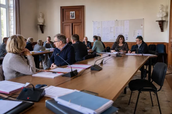 Salle municipale française préparant une réunion politique, avec micros, dossiers flous et une chaise vide