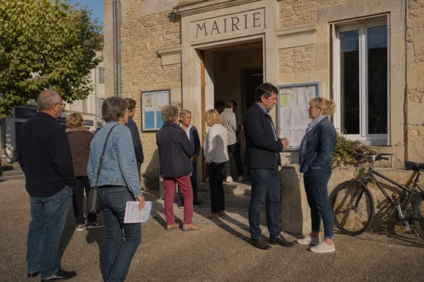 Citoyens anonymes devant une mairie française, illustrant la participation locale autour de la primaire de la gauche