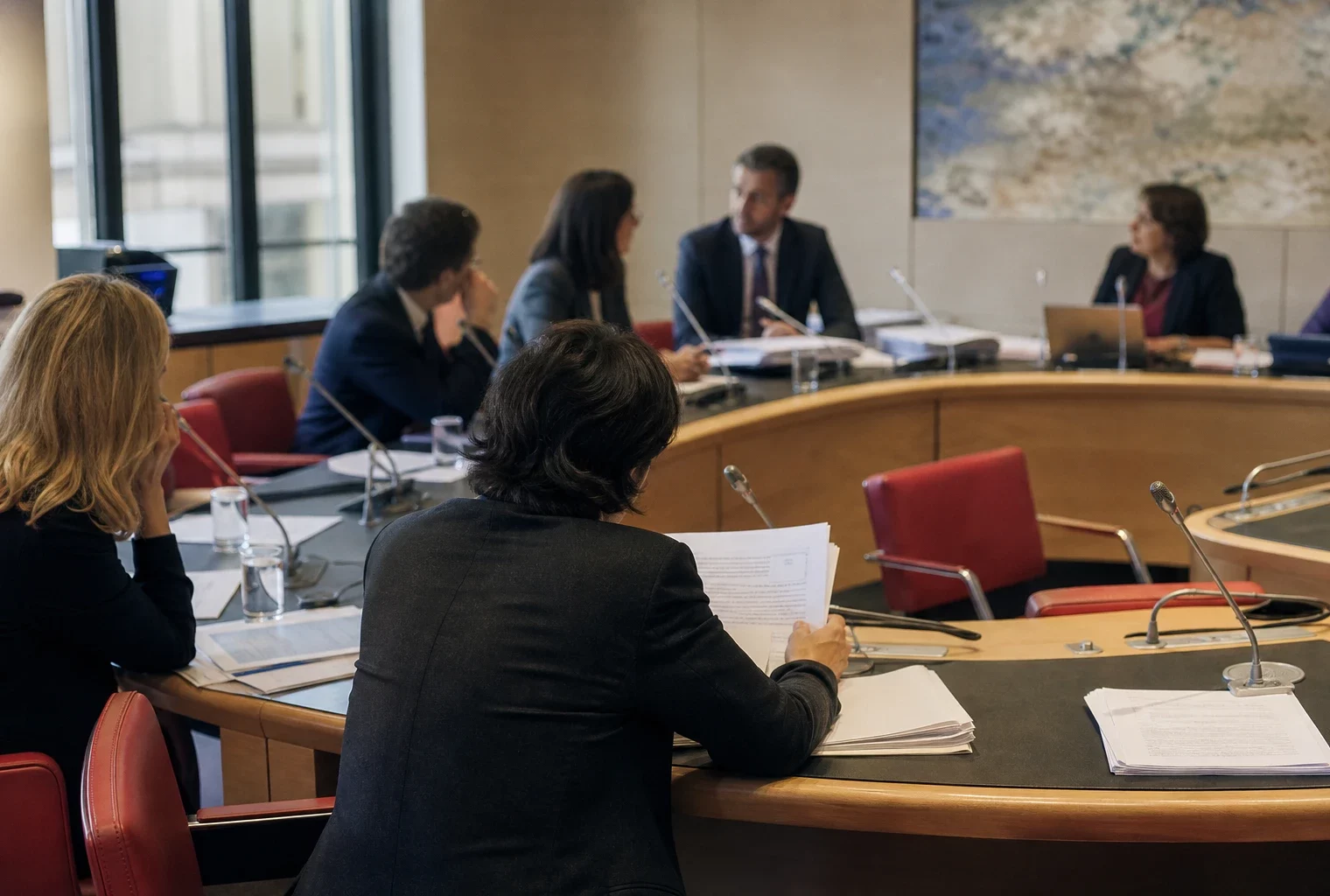 Réunion de commission parlementaire française avec élus anonymes, micros et dossiers autour d’une primaire présidentielle