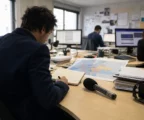 Journaliste préparant un sujet sur l’aide européenne à l’Ukraine dans une rédaction française lumineuse