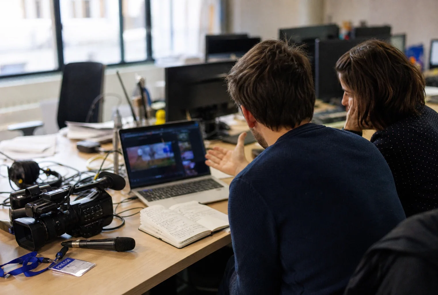 Journalistes anonymes vérifiant une vidéo politique manipulée dans une rédaction française lumineuse