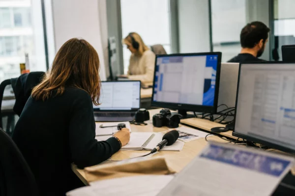 Journaliste préparant en rédaction un sujet sur la régulation des réseaux sociaux et la protection des mineurs