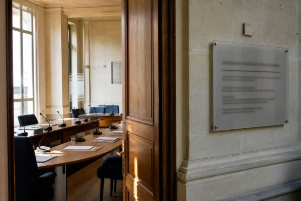 Couloir clair d’une institution publique française avec salle d’audition et micros sur une table