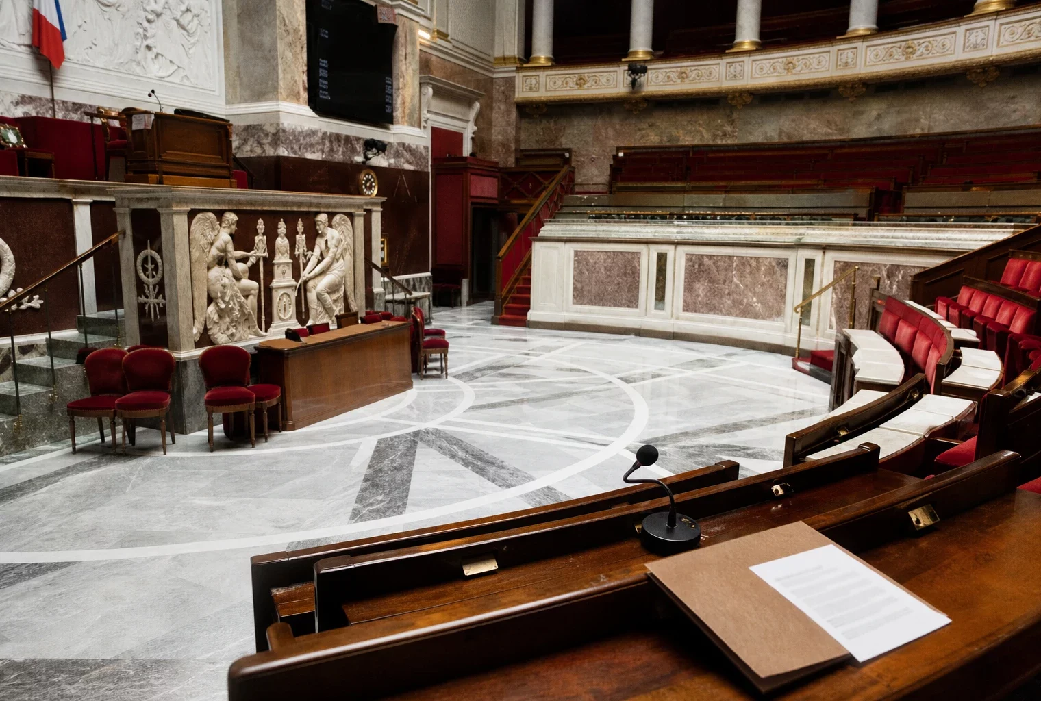 Salle parlementaire française vide, marbre blanc et sièges rouges, évoquant le retrait électoral de la gauche en PACA