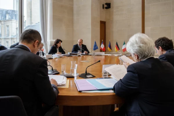 Réunion européenne sobre avec des délégués anonymes, dossiers et micros autour d’une table institutionnelle en France