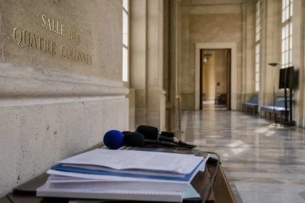 Salle institutionnelle française avec micros de presse, illustrant le débat politique et l’influence numérique de Rima Hassan