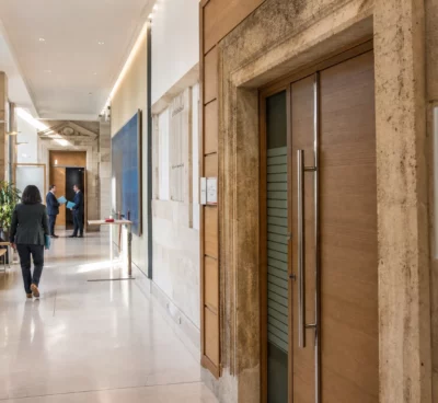 Hall clair d’un régulateur économique français, avec une porte de salle d’audition et des professionnels anonymes