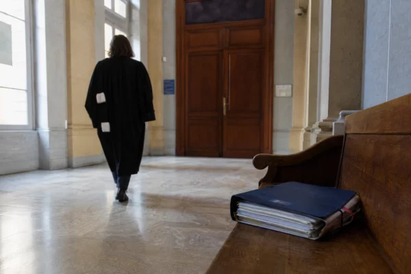 Hall lumineux d’un tribunal français avec dossier judiciaire fermé et agent anonyme après une condamnation