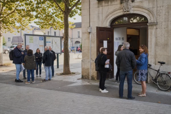 Habitants anonymes devant une mairie française, symbole d’un dialogue local autour de l’union de la gauche