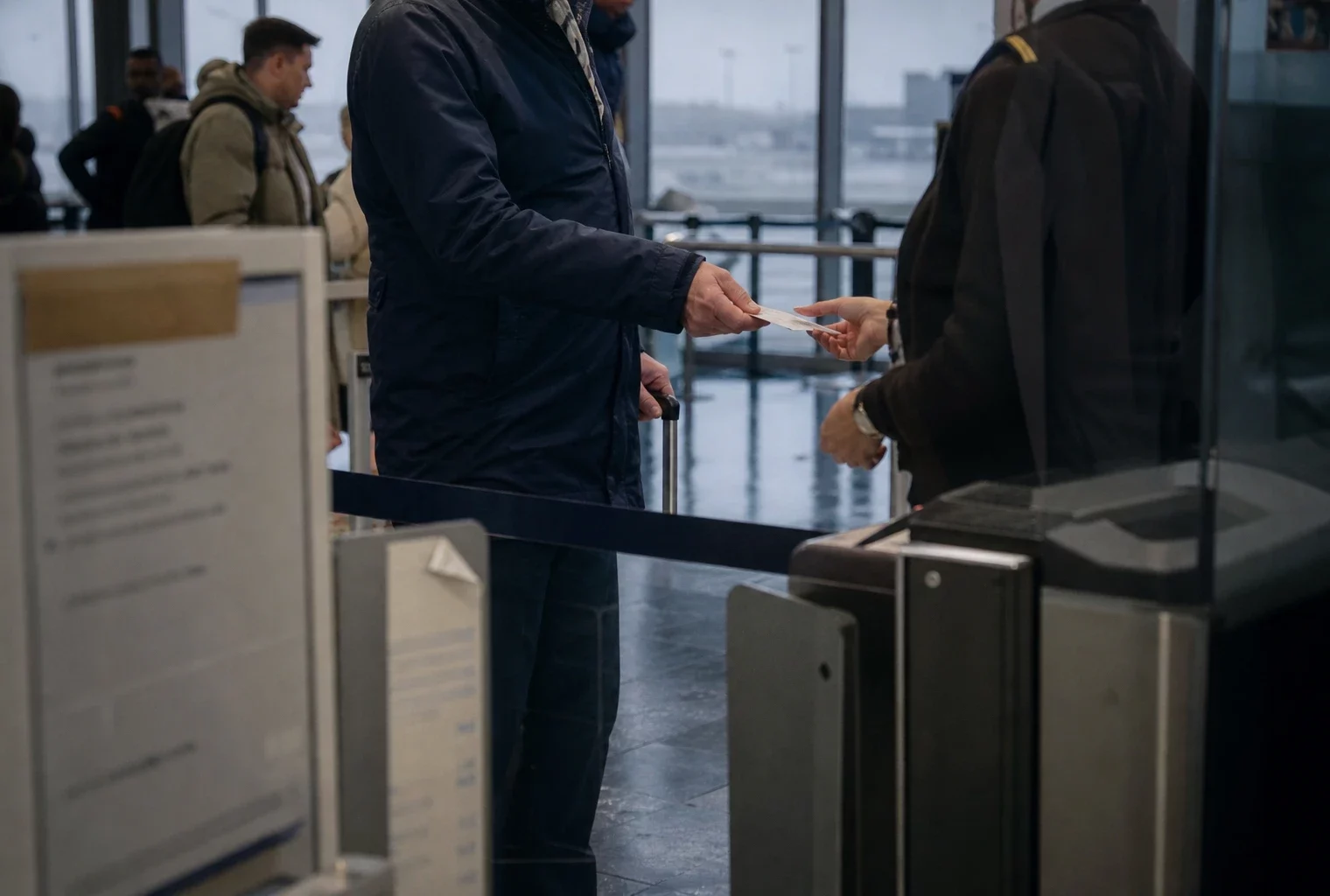 Hall de contrôle d’un aéroport régional français, files d’attente, portiques de sûreté et reflets humides au sol.