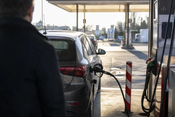 Une voiture à la pompe dans une station-service, image d’illustration sur le coût du carburant pour les trajets quotidiens