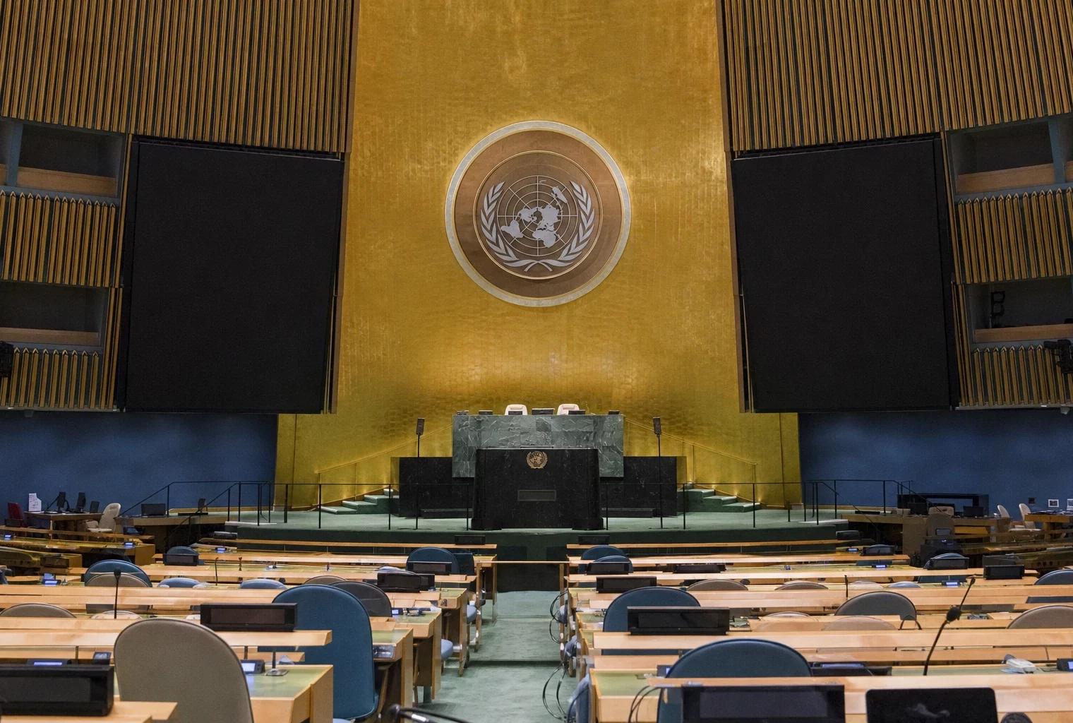 La tribune de l’Assemblée générale de l’ONU à New York, avec ses micros et les rangées de sièges autour.