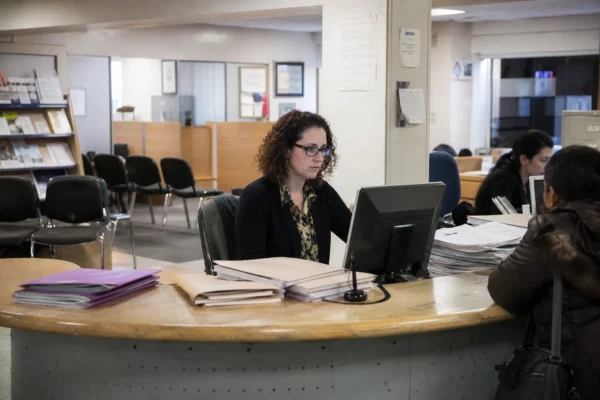 Guichet d’un bailleur social avec dossiers de demande et chaises d’attente, dans un bureau administratif français.