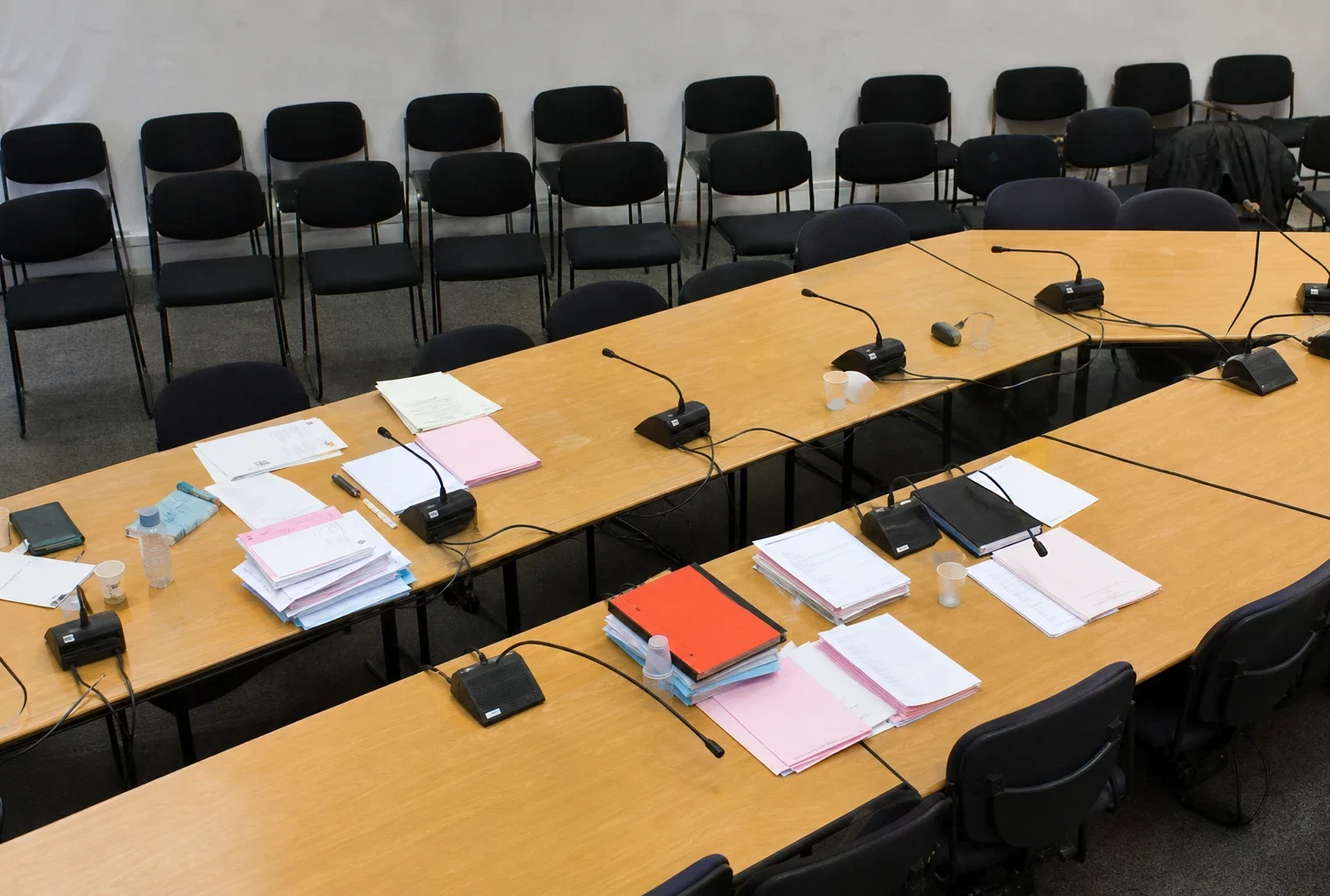 Salle de réunion du Parti socialiste avec tables, micros et dossiers, au moment où la direction tranche sur la primaire.