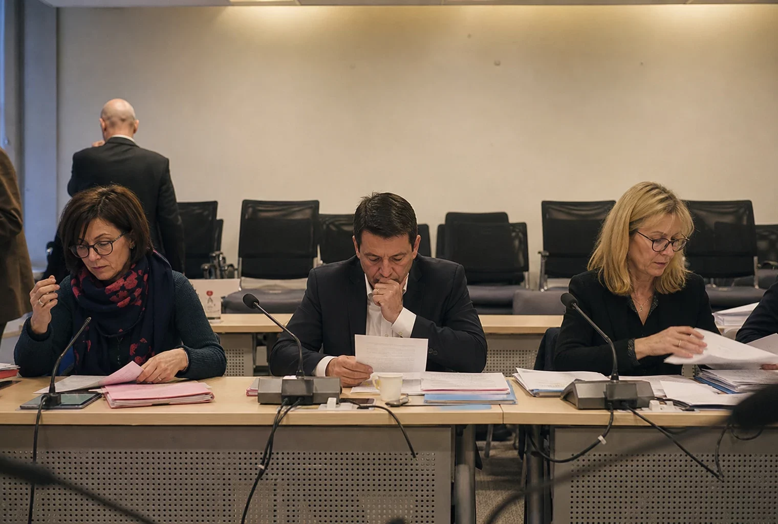 Salle de réunion du parti avec tables, micros et chaises, évoquant une décision interne sur une candidature.