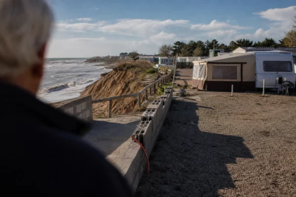 Un camping en bord de mer menacé par l’érosion côtière, avec des emplacements vides près de la plage.