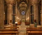 Intérieur de la cathédrale Saint-Étienne de Metz, bancs vides, chœur et autel au fond sous lumière chaude du soir.