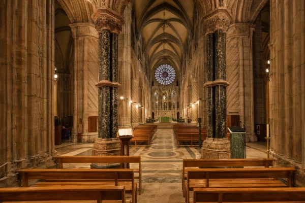 Intérieur de la cathédrale Saint-Étienne de Metz, bancs vides, chœur et autel au fond sous lumière chaude du soir.