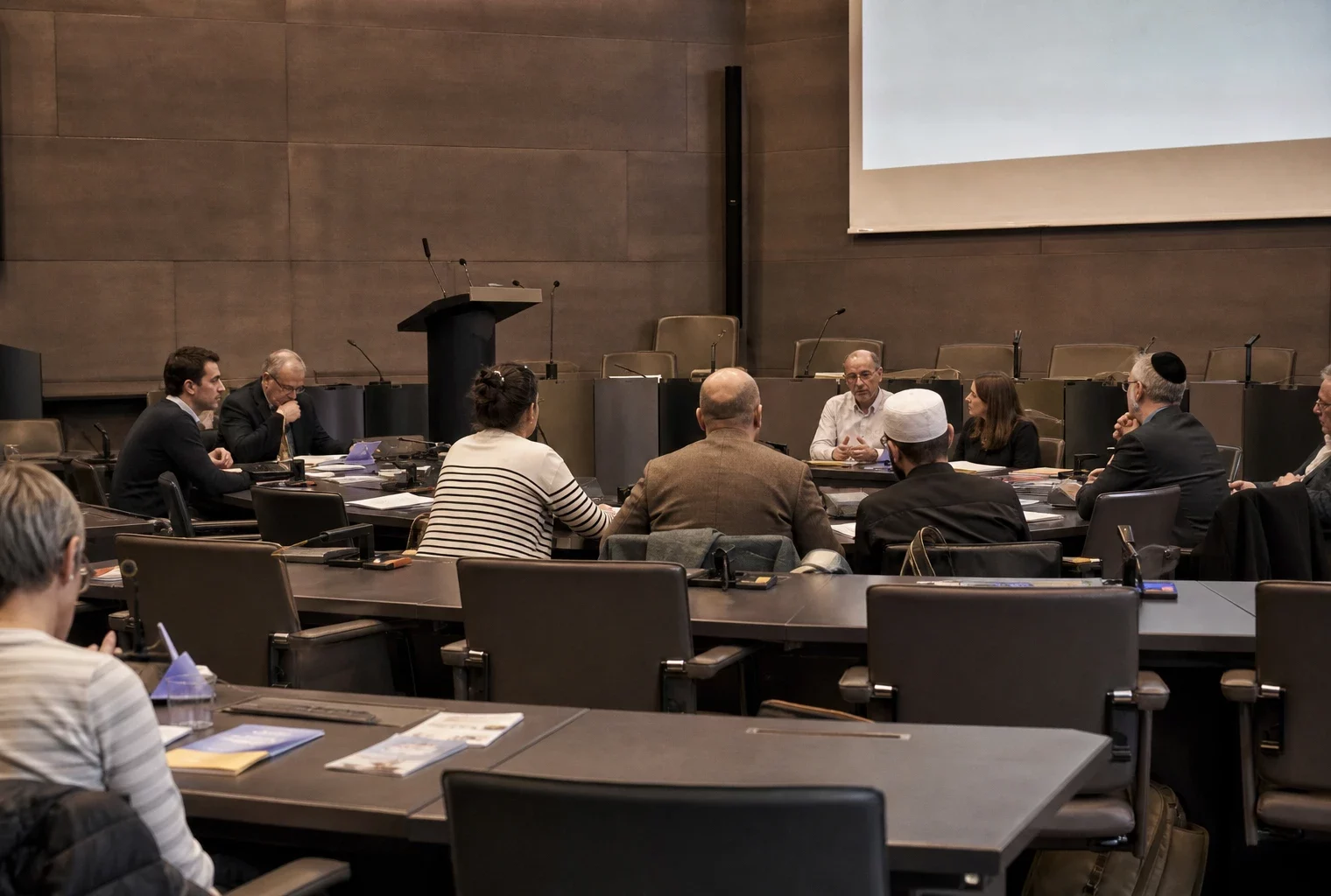 Salle du centre des congrès de Metz préparée pour une rencontre interreligieuse, avec chaises et pupitre.