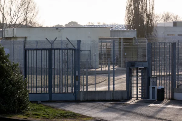 Vue d’un centre de rétention administrative avec clôtures et accès sécurisé, en France.