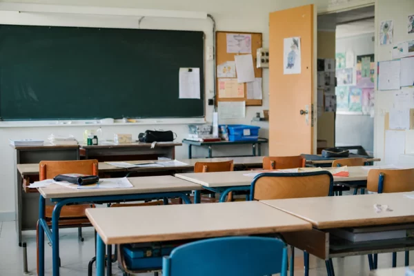 Une classe d’école publique avec des pupitres vides, image d’un service menacé par les fermetures de classes.