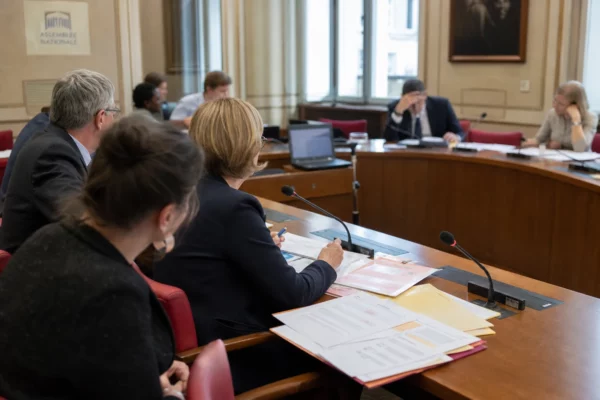 Réunion de commission parlementaire française sur les parrainages présidentiels, avec élus anonymes, micros et dossiers