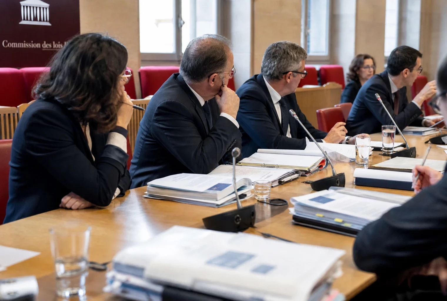 Réunion de commission parlementaire française sur les violences sexuelles, avec micros, dossiers et participants anonymes