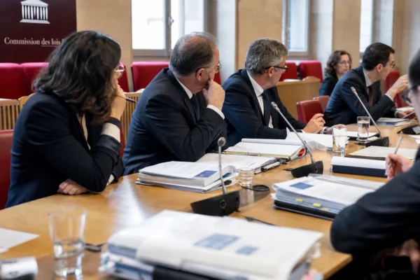 Réunion de commission parlementaire française sur les violences sexuelles, avec micros, dossiers et participants anonymes