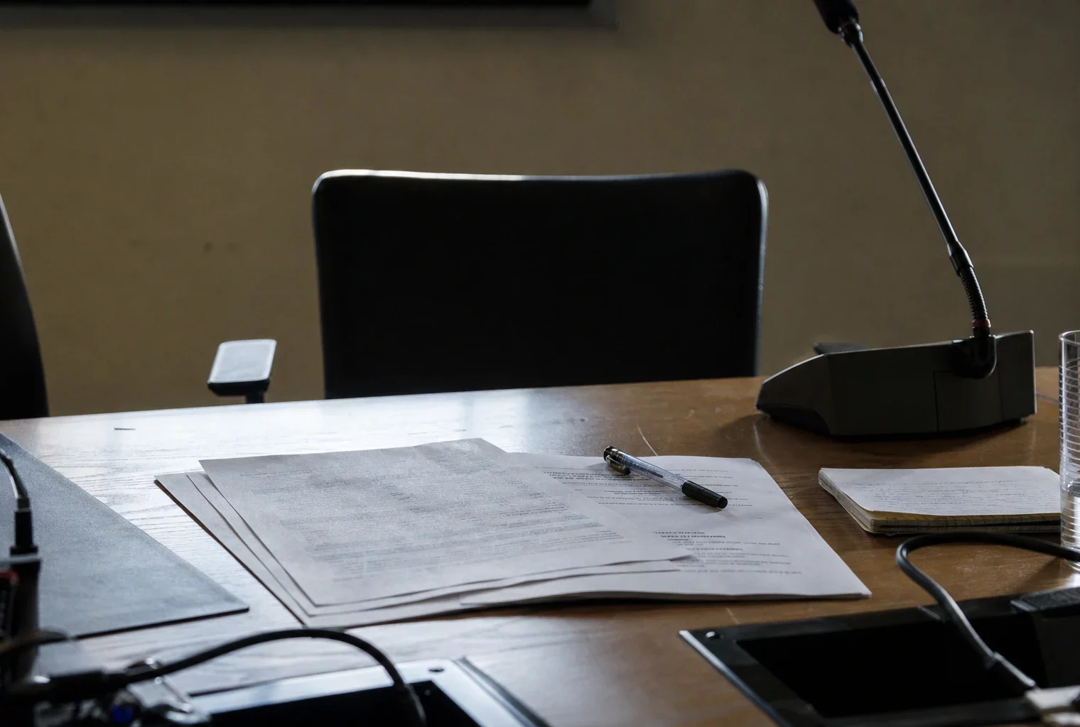 Des feuilles d’un communiqué politique sont posées sur une table de réunion, avec un stylo et quelques notes autour.