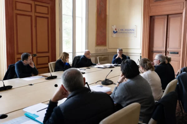 Salle municipale française avec habitants, micros et une chaise vide, évoquant la confiance envers la police municipale