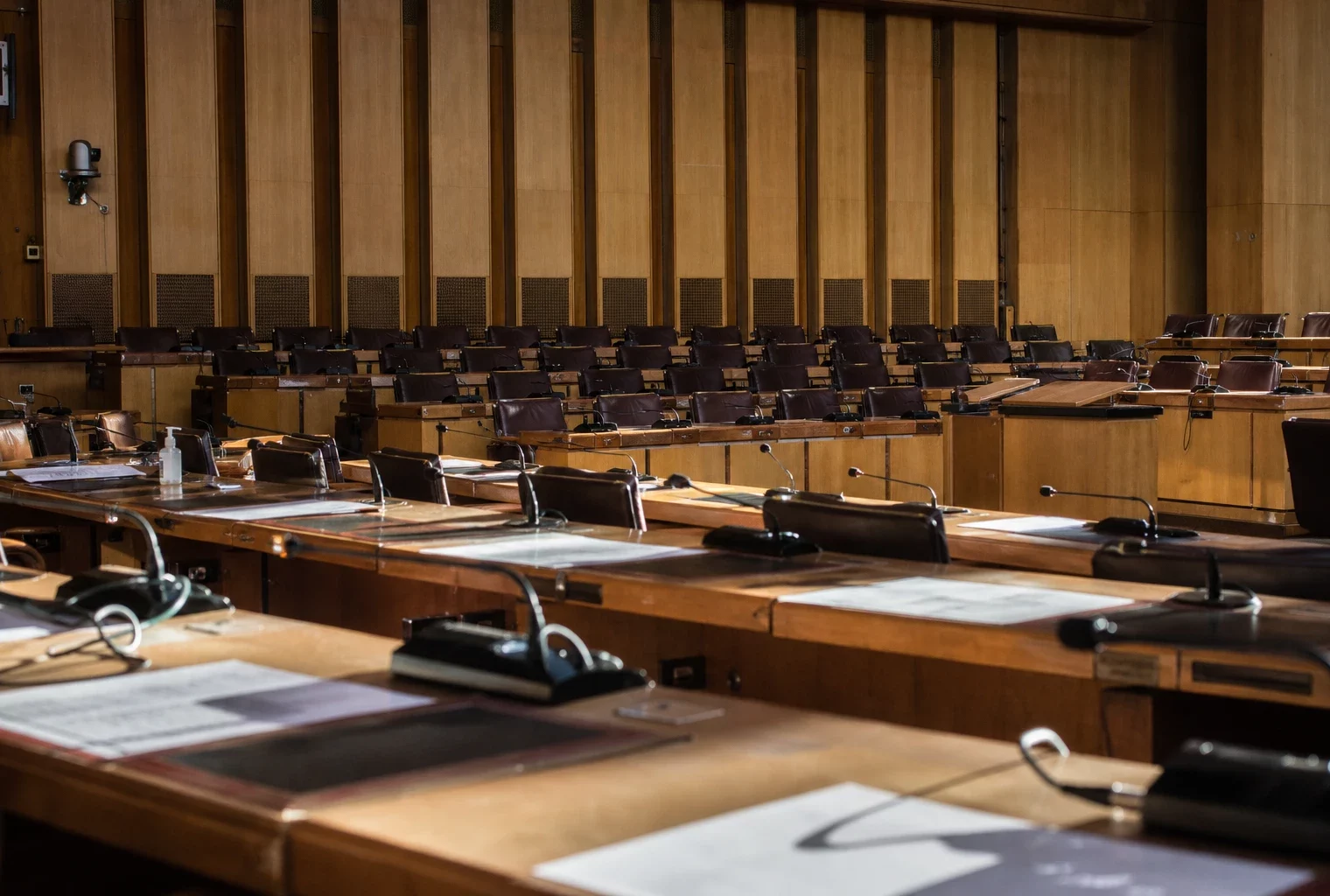Hémicycle du conseil départemental des Bouches-du-Rhône avec rangées de pupitres et micros, à Marseille.