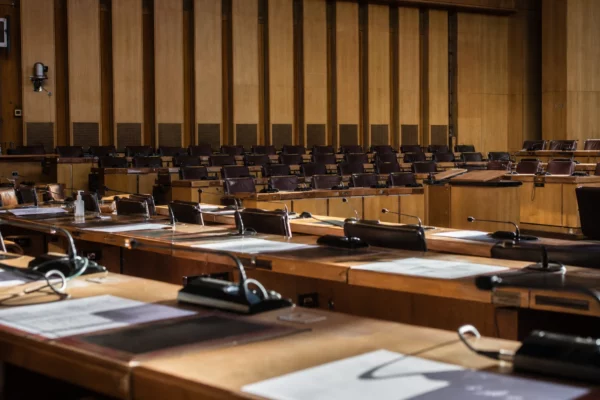 Hémicycle du conseil départemental des Bouches-du-Rhône avec rangées de pupitres et micros, à Marseille.