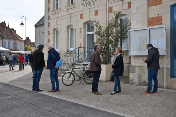 Habitants anonymes dans une rue de ville française près d’un équipement municipal, sur fond de débat civique